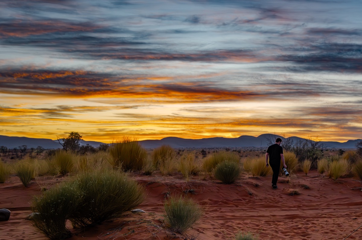 Walking through the Namib desert at sunset, camera in hand