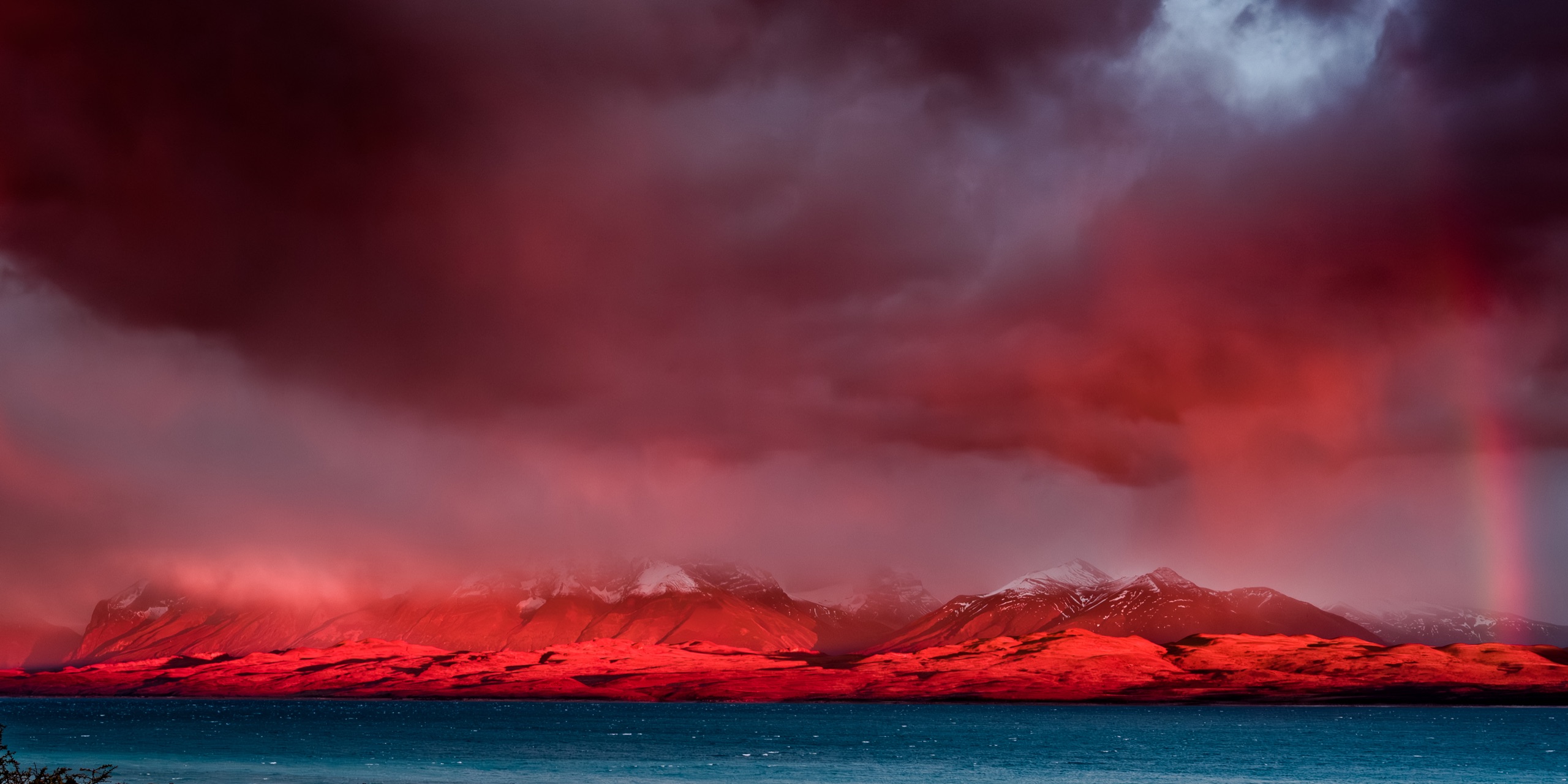Storm light turning mountains red over the water, Patagonia